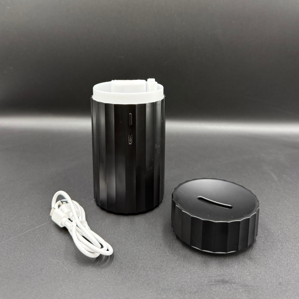 Black USB car diffuser with open lid and charging cable showing refill and charging port design